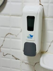 a soap dispenser attached to a toilet in a bathroom at mudha hotel in Hargeysa