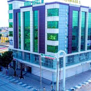a large building with glass windows on a city street at mudha hotel in Hargeysa