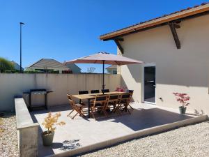 a patio with a table and chairs and an umbrella at Old Farmhouse in Chaumesnil