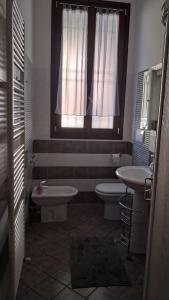 a bathroom with two toilets and a sink and a window at 95 by Le Suite in Lugo