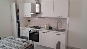 a kitchen with white cabinets and a sink and a stove at 95 by Le Suite in Lugo