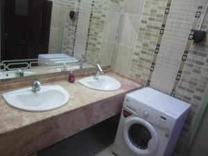 a bathroom with two sinks and a washing machine at العين الهيلي مصباح بيت 2 in Al Ain +6 photos