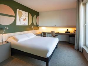 a hotel room with a large bed and a desk at ibis Styles Guéret in Guéret +57 photos