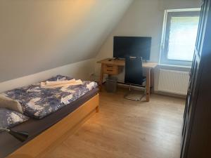a bedroom with a bed and a desk with a computer at Hotel Friesenhof in Westoverledingen