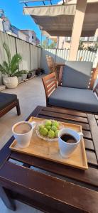 a tray of fruit and two bowls of coffee on a table at Kuća za odmor Emanuela in Vodice