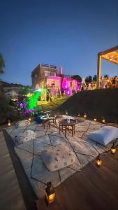 a lit up patio with pillows and tables at night at Nilamane in Asilah