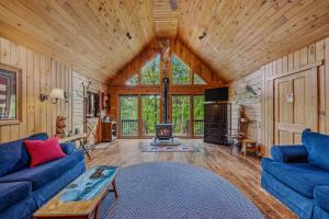 a living room with two blue couches and a fireplace at Seventh Heaven - Hot Tub, Pet Friendly, Grill, Wifi, Deck, Covered Porch, Family Friendly, Kid's Loft, King Bed in Great Cacapon