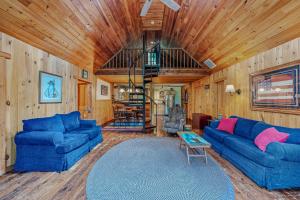 a living room with blue couches and a wooden ceiling at Seventh Heaven - Hot Tub, Pet Friendly, Grill, Wifi, Deck, Covered Porch, Family Friendly, Kid's Loft, King Bed in Great Cacapon