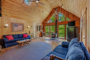 a living room with blue couches and a television in a cabin at Seventh Heaven - Hot Tub, Pet Friendly, Grill, Wifi, Deck, Covered Porch, Family Friendly, Kid's Loft, King Bed in Great Cacapon