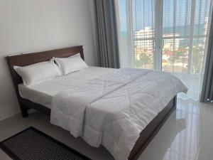 a bed in a bedroom with a large window at Bay Nest in Wellawatta