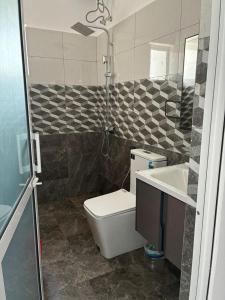 a bathroom with a toilet and a sink and a shower at Bay Nest in Wellawatta +8 photos