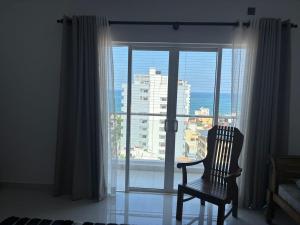 a chair sitting in front of a window with a view at Bay Nest in Wellawatta