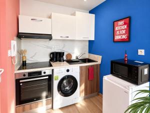 a kitchen with a washing machine and a microwave at Le Nid de MIMI in Bollène