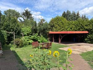 a picnic shelter with two benches in a garden at Alte Schule Rietz in Treuenbrietzen