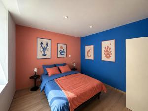 a bedroom with a blue and orange wall at Le Nid de MIMI in Bollène