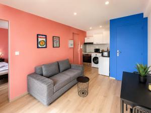 a living room with a couch and a kitchen at Le Nid de MIMI in Bollène