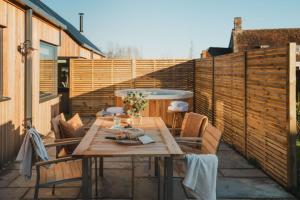 a patio with a table and chairs and a fence at Adam in Marlborough