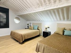 a bedroom with two beds and a ceiling at Villa 1-12 Personas a 3 minutos de las playas in Villanueva de Arosa