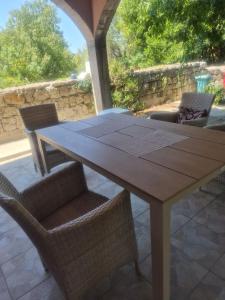 a wooden table and chairs on a patio at Apartmani “Dunja” in Kraljevići