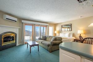 a living room with a couch and a bed and a fireplace at Nordic Village Condominium Resort in Jackson