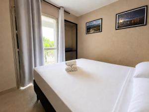 a bedroom with a white bed with a window at Hotel Montana Aeroporto by Bsb Inn in Brasília