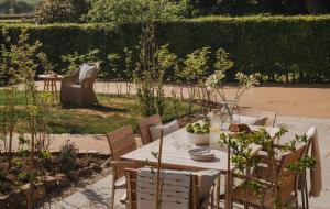 a table and chairs in a garden with a chair at Kennet in Marlborough
