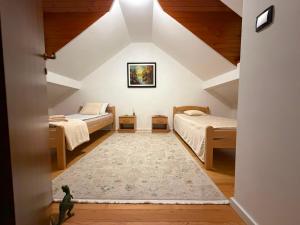 a attic bedroom with two beds and a rug at Plavo oko in Sarajevo