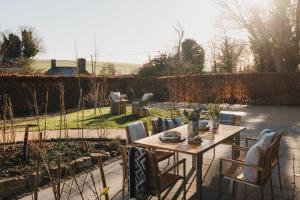 a patio with a table and chairs in a garden at Kennet in Marlborough +11 photos