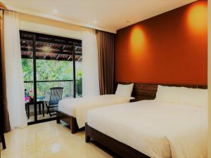 a hotel room with two beds and a balcony at Maison De Hoi An Boutique Homestay in Hoi An +83 photos
