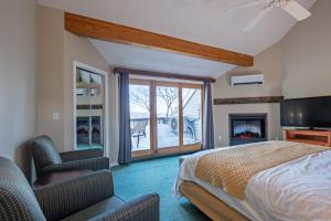 a bedroom with a bed and a tv and a fireplace at Nordic Village Condominium Resort in Jackson