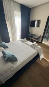a bedroom with a large bed with a table and a window at La Torre di LuSi in Castellammare di Stabia