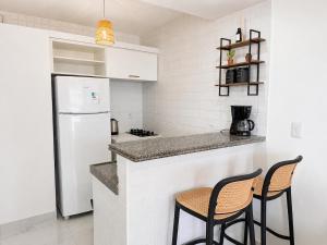 a kitchen with two chairs and a white refrigerator at Premium Apartment with Ocean View in Santiago