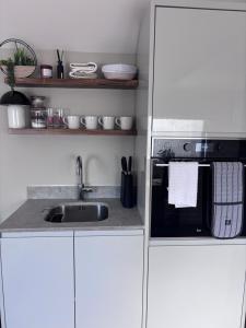 a kitchen with a sink and a microwave at Riverhill in Abersoch