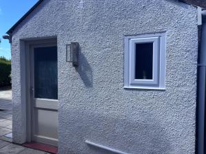 a building with a white door and a window at Riverhill in Abersoch