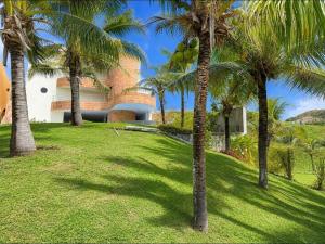 a group of palm trees in front of a house at Premium Apartment with Ocean View in Santiago