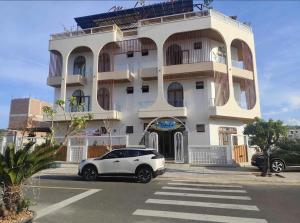 a white car parked in front of a building at Minh's homestay in Long Bình