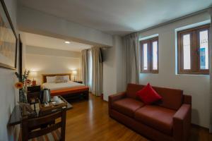 a hotel room with a couch and a bed at San Agustin El Dorado in Cusco +63 photos