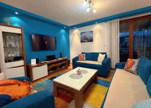 a living room with blue furniture and a tv at Plavo oko in Sarajevo