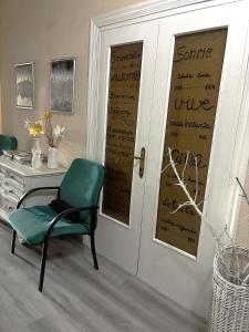 a room with a door with a desk and a green chair at Hospedaje Botin in Santander