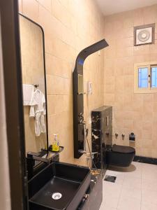 a bathroom with a black sink and a mirror at الارجان للشقق المفروشة in Al Nairyah