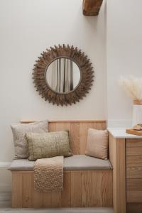 a mirror on a wall above a bench with pillows at Ridgeway in Marlborough +9 photos