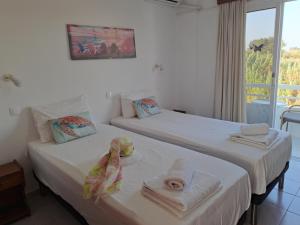 two beds in a room with a window at Annabel Apartments in Theologos