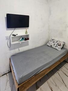 a bed in a room with a tv on a wall at Casa Vigia 1 Quarto in Vigia