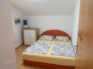 a small bedroom with a bed and a dresser at Apartments Tutto Bene in Jajce
