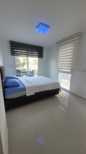 a bedroom with a bed with blue sheets and windows at Urla Sea View House in Urla