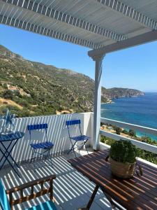 a deck with chairs and a table and a view of the ocean at Agnanti in Akhladherí