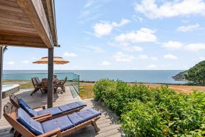a deck with chairs and an umbrella and the ocean at House 38 in Looe