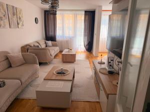 a living room with a couch and a tv at Elite Suites - Vogošća in Vogošća