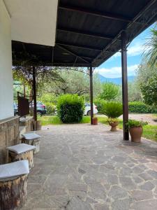 a patio with benches and awning with mountains in the background at Villa Filomena in Montoro Inferiore +13 photos