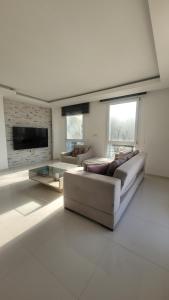 a large living room with couches and a tv at Urla Sea View House in Urla